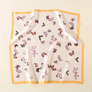 Detailed view of satin square scarf featuring colorful butterfly prints and orange border