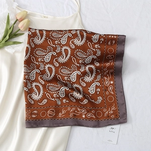 Close-up of silk square scarf with paisley pattern and grey contrast border on white background