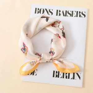 Detailed view of a soft satin scarf featuring colorful butterfly prints and yellow borders