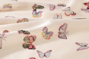 Macro detail of silky satin fabric with colorful butterfly prints and soft texture