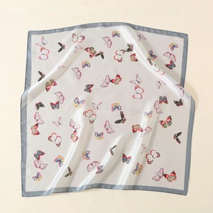 Macro detail of high-quality satin scarf showing smooth texture and colorful butterfly print