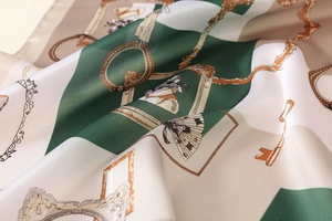 Detail of silk-like satin scarf featuring baroque floral prints and elegant golden patterns