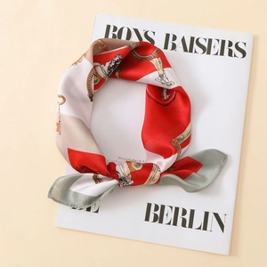 Detailed close-up of a luxury satin silk scarf with vintage key patterns and elegant knots