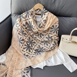 Detailed texture of beige cotton linen scarf with gray floral and chain patterns on sofa