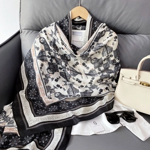 Detail of bohemian geometric print scarf in silk-like fabric hanging on a wooden hanger