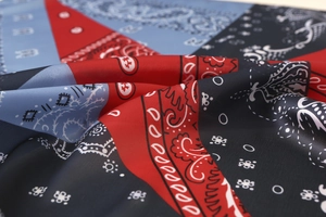 Detailed view of paisley silk scarf with red and blue geometric blocks and soft texture