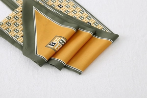 Detailed close-up of retro striped silk scarf with olive green and orange B logo prints