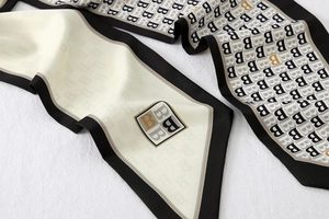 Detailed close-up of retro striped silk scarf with letter B pattern and smooth texture