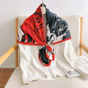 Détail d'un élégant grand foulard en soie avec roses rouges et sergé diagonal chic