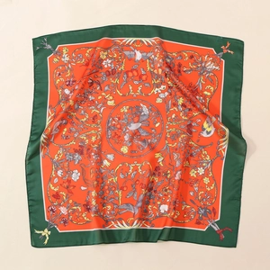 Detailed flat lay of a satin scarf featuring vintage bird and orange floral patterns