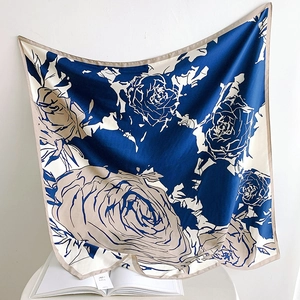 Détail d'un élégant foulard en soie sergé bleu marine et beige sur un magazine