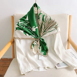 Gros plan d'un foulard élégant en soie avec boucle dorée sur une chemise blanche