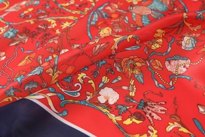 Macro shot of high-quality red satin silk scarf with vintage floral and bird print details