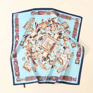 Detail of light blue satin scarf with baroque floral patterns and silk-like texture