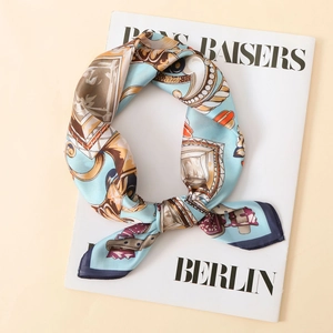 Detailed close-up of light blue satin scarf with vintage gold and navy baroque patterns