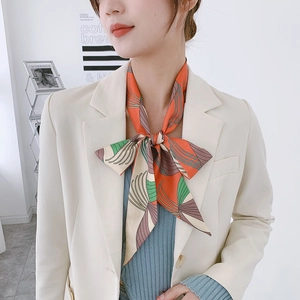 Detail of floral satin skinny scarf with abstract patterns tied around a model's neck