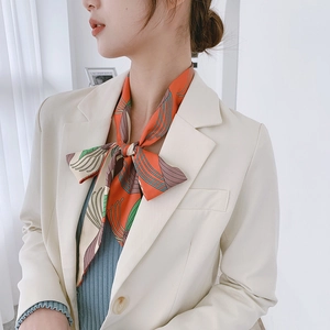 Close-up of floral silk skinny scarf tied in a bow around neck for office wear