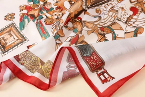 Detailed view of satin scarf showing vintage bird illustrations and red stitched edges