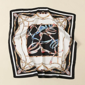 Detailed flat lay of a satin square scarf featuring classic equestrian chain and belt prints
