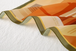 Detailed close-up showing satin finish and geometric patterns of this silk-like scarf