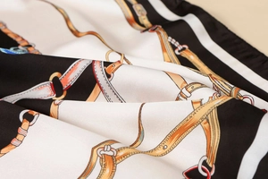 Close-up of satin silk scarf featuring equestrian chain print and smooth texture