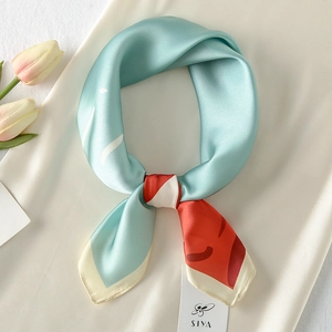 Detail of mint green satin square scarf with orange geometric patterns and tulips