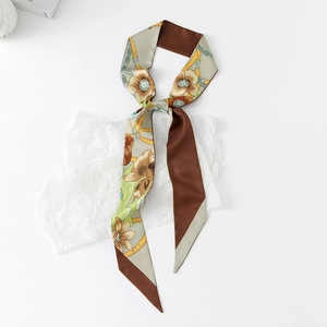 Detail of floral and chain print skinny silk scarf on white textured paper background