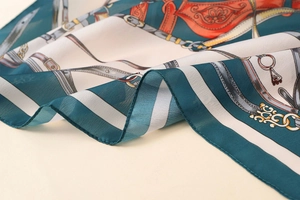 Detailed macro view of satin printed scarf with equestrian chain patterns and silk texture