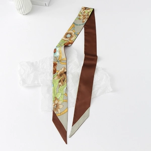 Detail of floral satin twilly scarf with elegant lily prints and metal chain patterns
