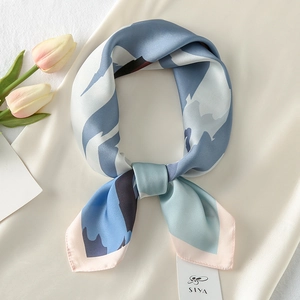 Detailed shot of an abstract patterned satin scarf tied elegantly next to tulips