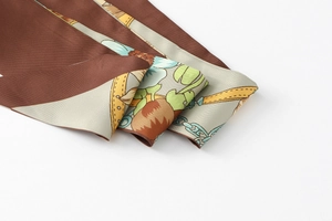 Close-up of vintage floral and chain print silk scarf with smooth polished texture