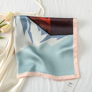 Detailed close-up of abstract mountain print silk scarf on a white dress with tulips