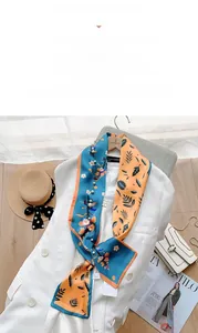 Detail of floral pattern silk scarf paired with elegant white pearl necklace accessory