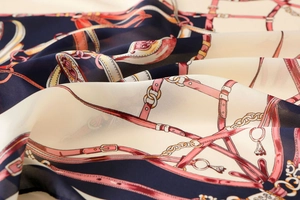Detailed macro view of the equestrian chain print on soft navy and beige satin fabric