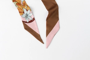 Detail of floral and geometric silk scarf showing tapered ends and dual-sided patterns