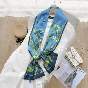 Detail of blue floral silk scarf with pearls elegantly draped on a white blazer