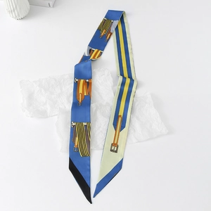 Detailed macro view of the equestrian belt and buckle patterns on the blue silk twilly scarf