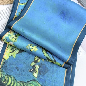 Close-up of silk scarf with artistic blue floral print and washing label detail