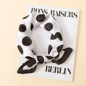 Close-up of black and white polka dot satin scarf with a soft silky texture