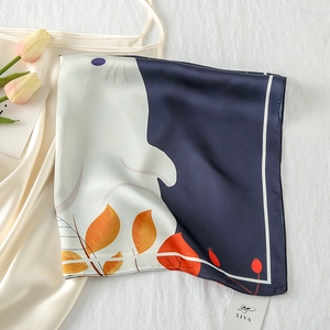 Detailed close-up of rabbit and floral print on satin silk square scarf with brand tag