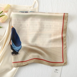 Detailed macro view of an elegant silk scarf featuring artistic illustration and gold trim