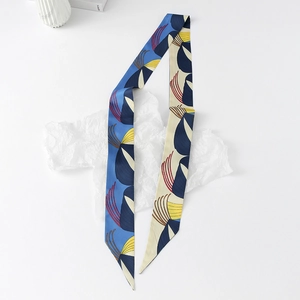 Detail of blue and beige floral silk twilly scarf with abstract geometric print on paper