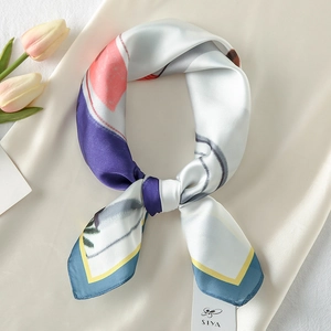 Detailed close-up of colorful silk-like scarf with geometric print on soft satin fabric