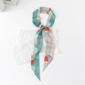 Detail of floral skinny silk scarf with orange and blue geometric patterns in soft green