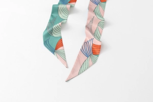 Detail of floral skinny silk scarf with mint green and pink abstract geometric patterns