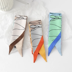 Close-up of silk-feel floral skinny scarves with abstract lines and geometric patchwork