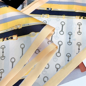 Detailed close-up of a digital printed silk scarf with equestrian horsebit patterns