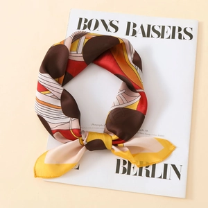 Detailed view of luxury satin scarf with polka dots and geometric stripes on magazine