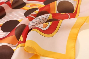 Detailed view of satin floral scarf with yellow edges and polished geometric patterns