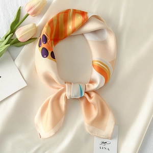 Detailed close-up of a satin silk scarf with artistic floral prints and smooth texture